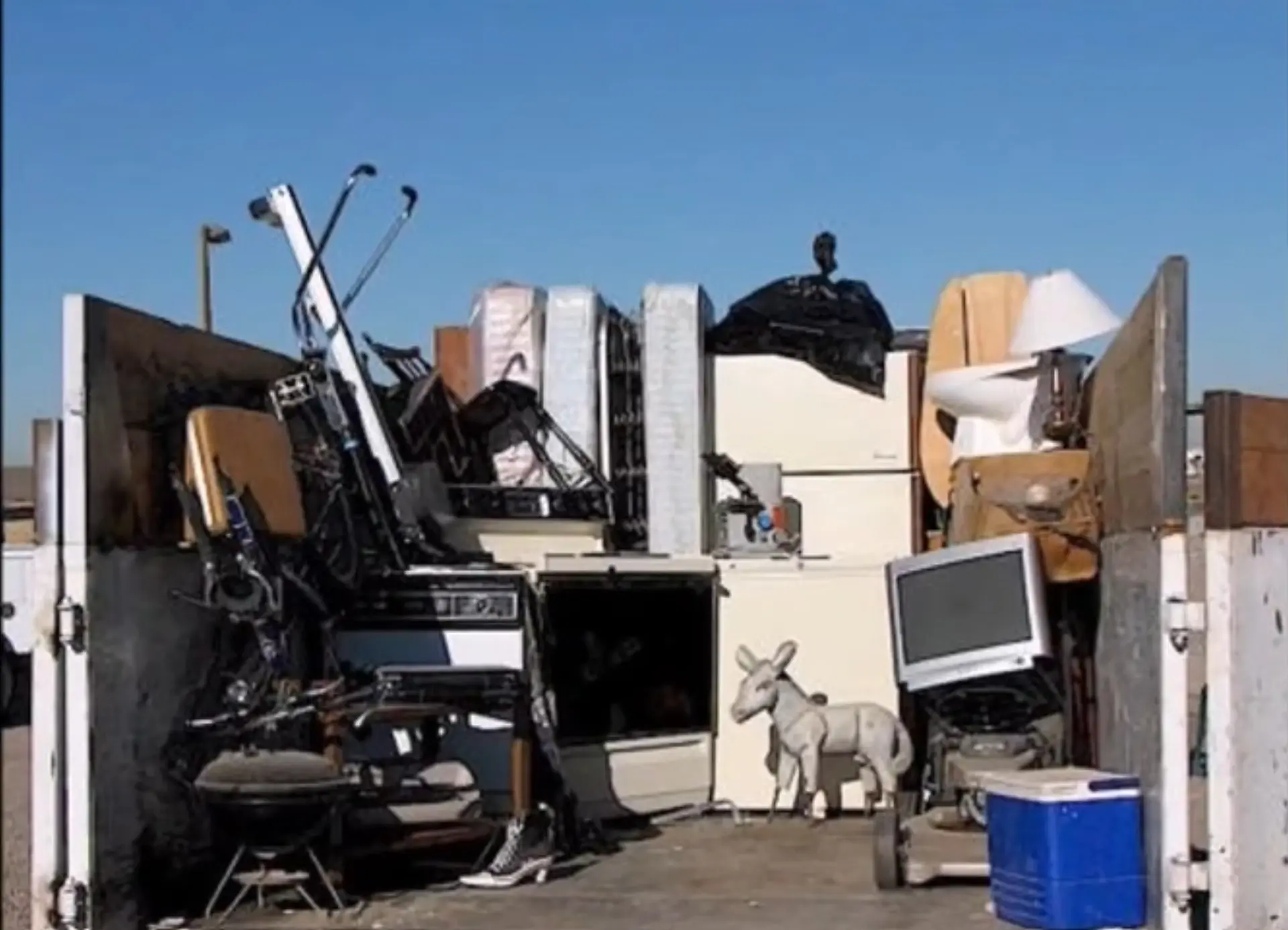 Junk removal is priced by volume, appliances and furniture pile ready for pickup