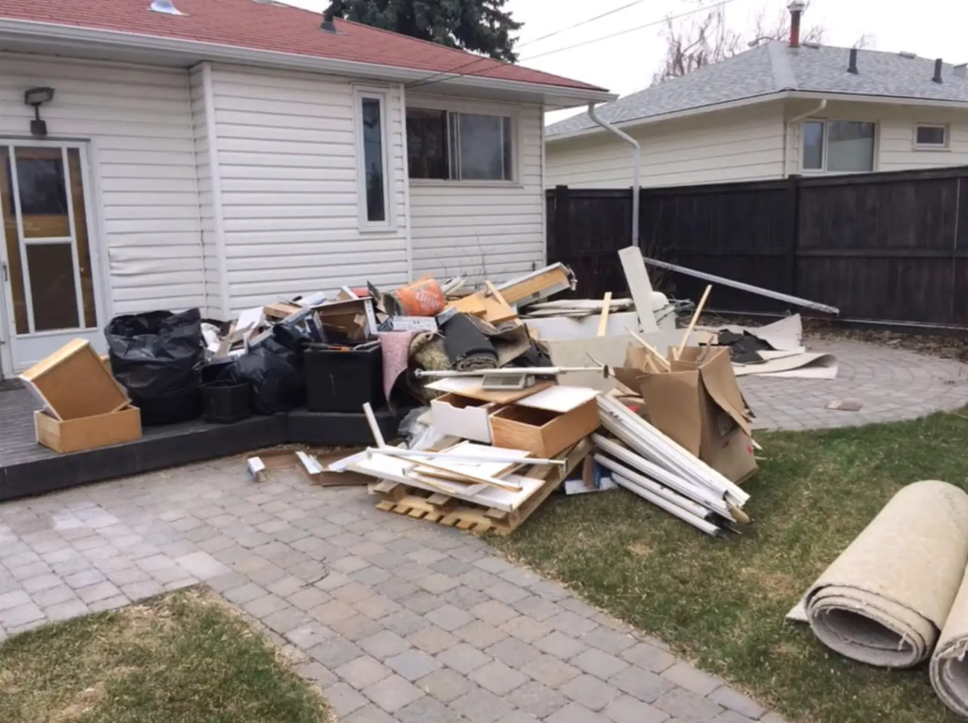 Backyard patio pile of renovation and household debris during a property cleanout